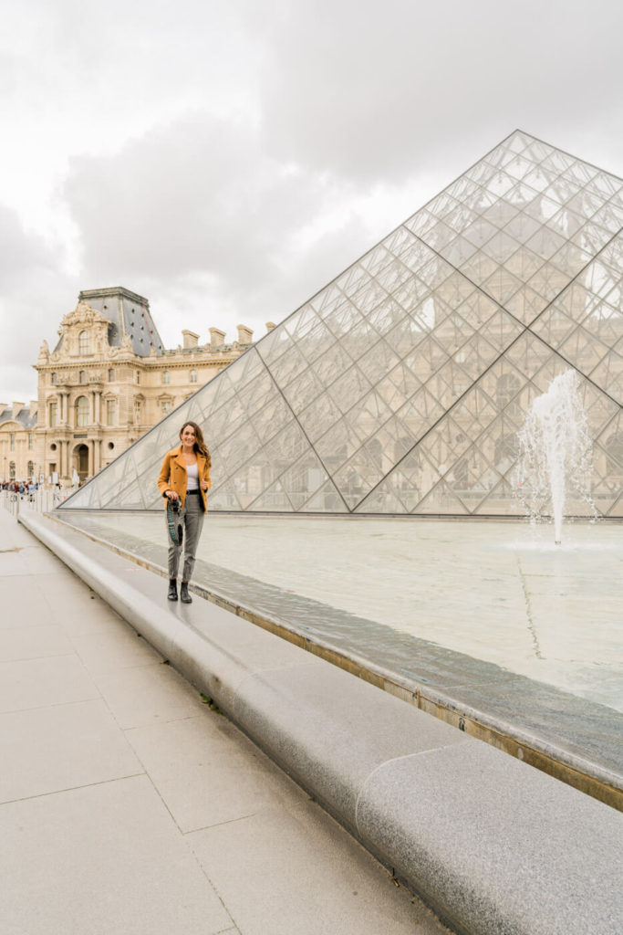 Posing in front of the Louvre pyramid, one of the best photo spots in Paris