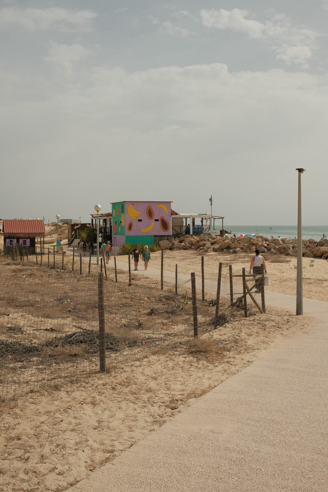 Walking to a beachfront bar at Farol Beach in the Algarve, Portugal